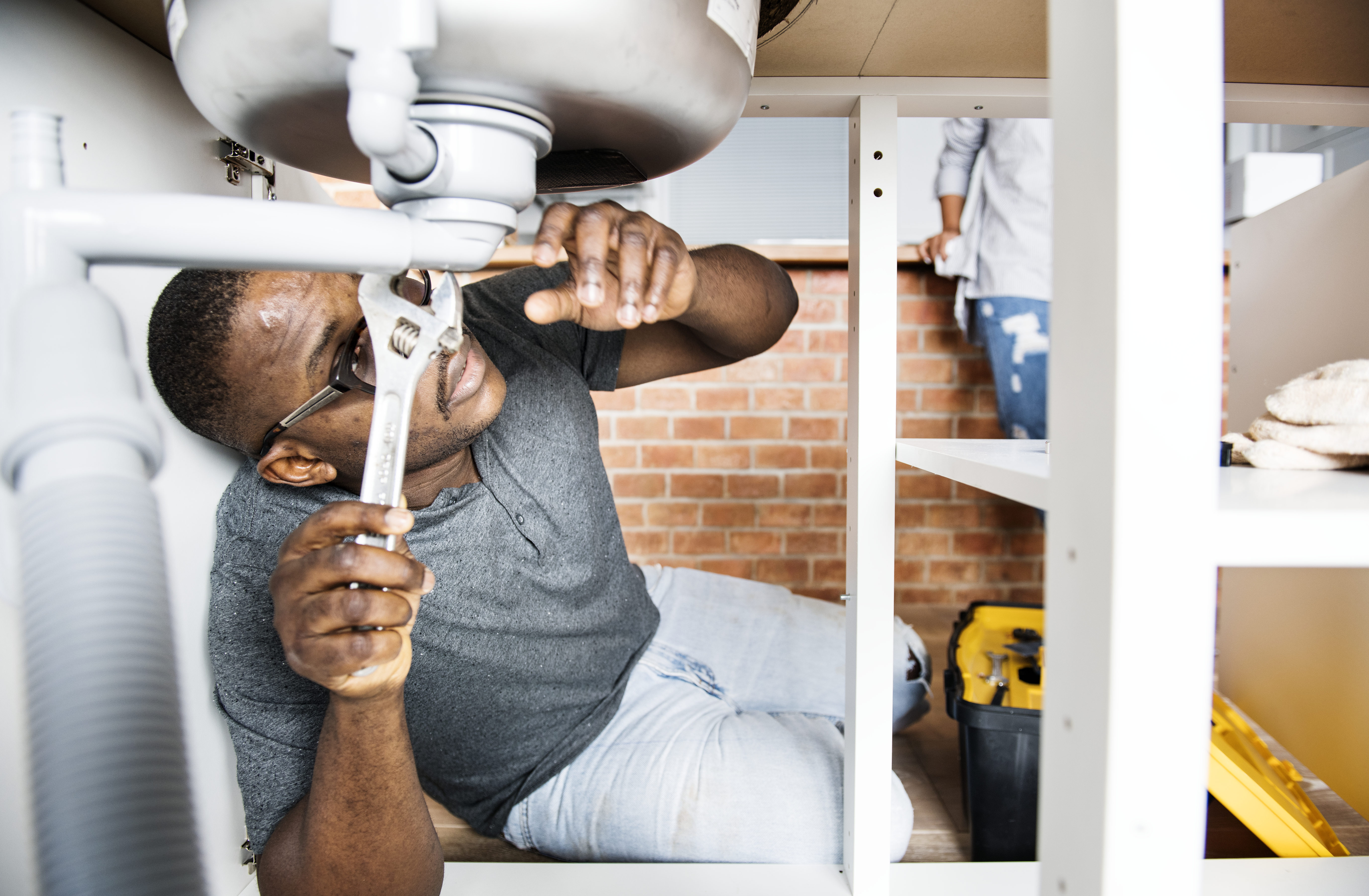 Plumber with goggles working on drain