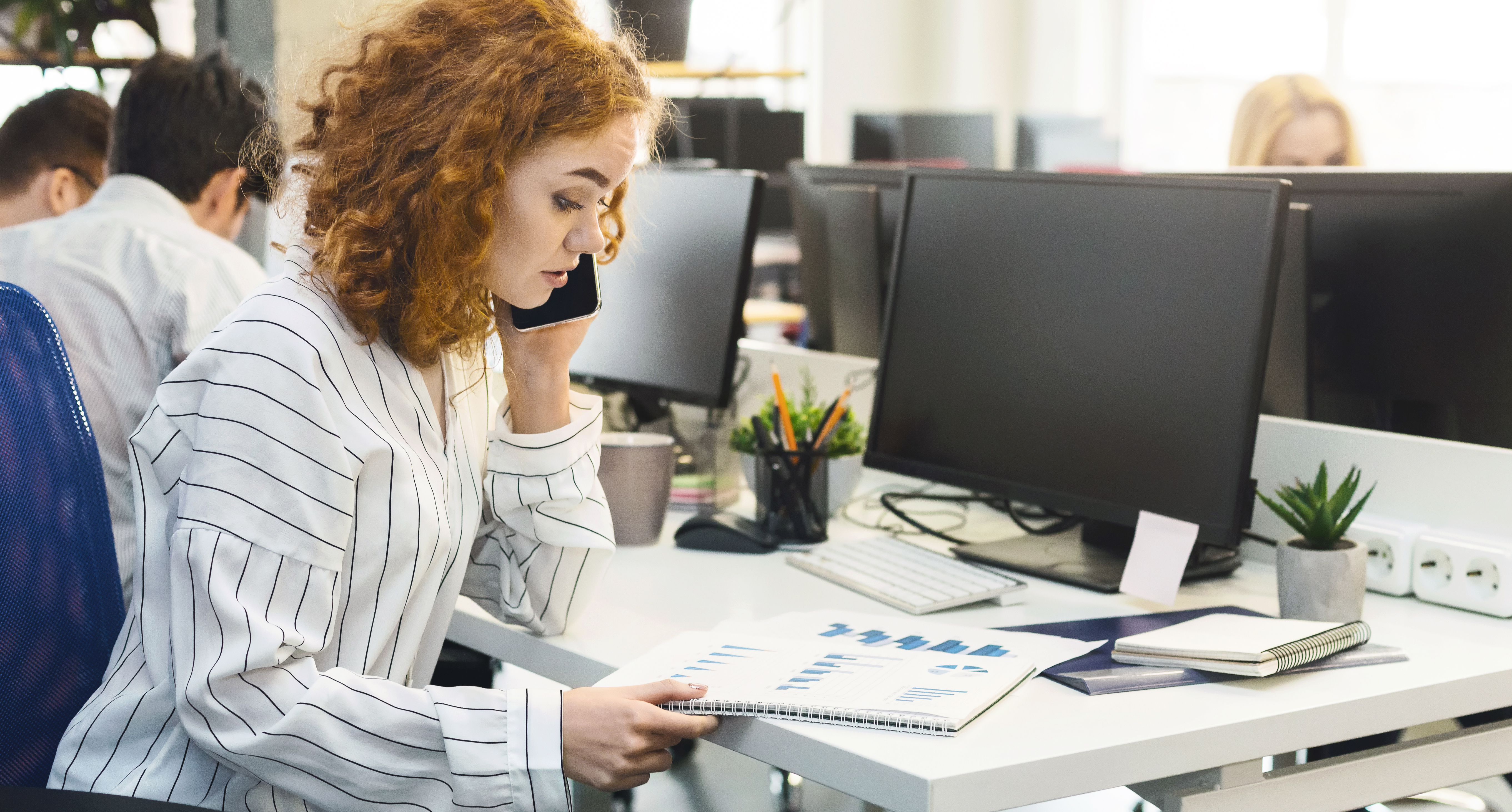 Women on phone with data printouts